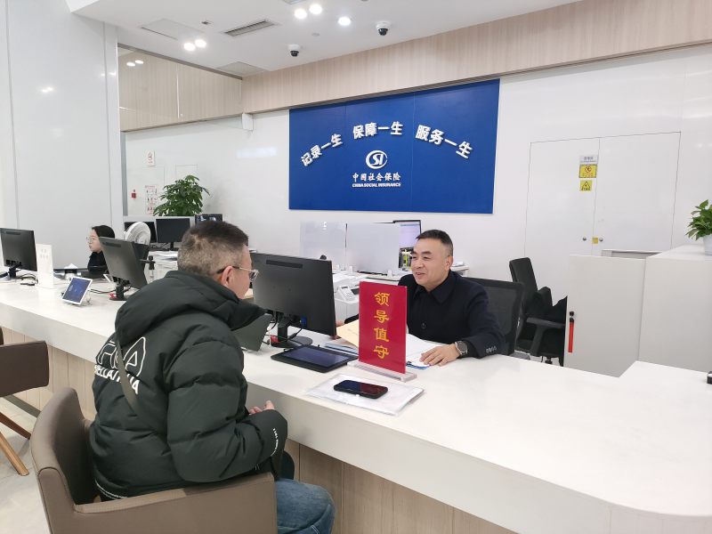 刘岱正耐心细致地为办事群众答疑解惑。黄成薇供图